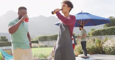 Mutlu erkek arkadaşlar güneşli bir günde bahçede konuşuyor ve bira içiyor. Birlikte dışarıda kaliteli zaman geçirmek..