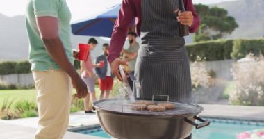 Mutlu erkek arkadaşlar güneşli bir günde bahçede konuşuyor ve bira içiyor. Birlikte dışarıda kaliteli zaman geçirmek..