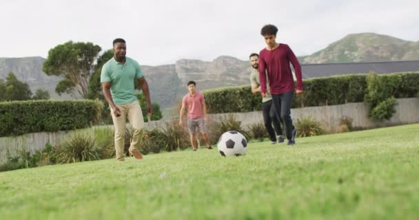 Szczęśliwy Zróżnicowany Mężczyzna Przyjaciele Grający Piłkę Nożną Ogrodzie Słoneczny Dzień — Wideo stockowe