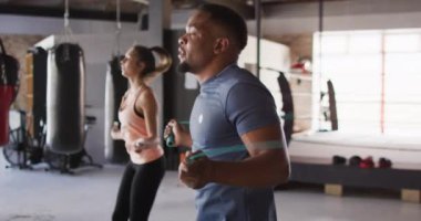 Spor salonunda ip atlayan, zinde kadın ve adamın videosu. aktif, formda, sportif ve sağlıklı yaşam tarzı, spor konsepti egzersizi.