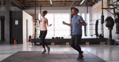 Spor salonunda ip atlayan, zinde kadın ve adamın videosu. aktif, formda, sportif ve sağlıklı yaşam tarzı, spor konsepti egzersizi.