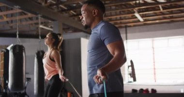 Spor salonunda ip atlayan, zinde kadın ve adamın videosu. aktif, formda, sportif ve sağlıklı yaşam tarzı, spor konsepti egzersizi.