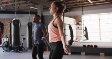 Spor salonunda ip atlayan, zinde kadın ve adamın videosu. aktif, formda, sportif ve sağlıklı yaşam tarzı, spor konsepti egzersizi.