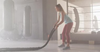 Beyaz kadın spor salonunda iple antrenman yaparken çekilmiş bir video. aktif, formda, sportif ve sağlıklı yaşam tarzı, spor konsepti egzersizi.