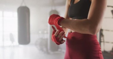 Beyaz bir kadının kasetleri bağlayıp spor salonunda boks antrenmanına hazırlandığı bir video. aktif, formda, sportif ve sağlıklı yaşam tarzı, spor konsepti egzersizi.