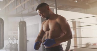 Formda bir Afrikalı Amerikalının spor salonunda boks antrenmanına hazırlandığı video. aktif, formda, sportif ve sağlıklı yaşam tarzı, spor konsepti egzersizi.