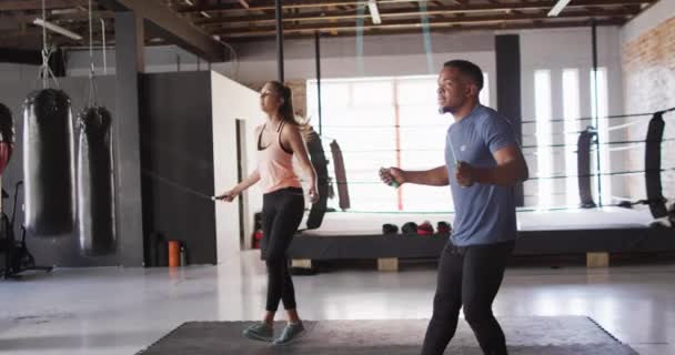 ジムでロープジャンプに飛び乗る多様な女性と男のフィット感のビデオ アクティブ フィット スポーティーで健康的なライフスタイル ジムのコンセプトでの運動 — ストック動画