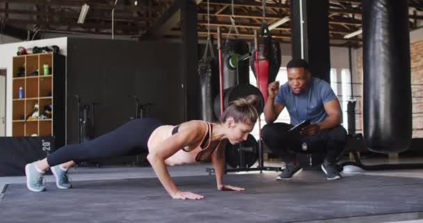 非洲裔美国男性教练激励高加索女人做俯卧撑的视频 积极的 健康的 运动的 健康的生活方式 — 图库视频影像