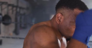 Afrika kökenli Amerikalı bir adamın spor salonunda boks yaptığı bir video. aktif, formda, sportif ve sağlıklı yaşam tarzı, spor konsepti egzersizi.
