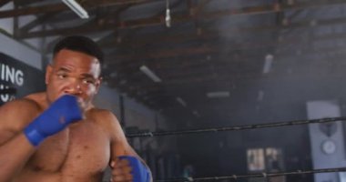 Afrika kökenli Amerikalı bir adamın spor salonunda boks yaptığı bir video. aktif, formda, sportif ve sağlıklı yaşam tarzı, spor konsepti egzersizi.