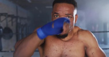 Afrika kökenli Amerikalı bir adamın spor salonunda boks yaptığı bir video. aktif, formda, sportif ve sağlıklı yaşam tarzı, spor konsepti egzersizi.