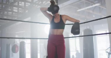 Spor salonunda kutu eğitiminden sonra dinlenen formda ve yorgun beyaz kadın videosu. aktif, formda, sportif ve sağlıklı yaşam tarzı, spor konsepti egzersizi.