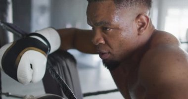 Formda ve yorgun bir Afrikalı Amerikalının spor salonunda kutu eğitiminden sonra dinlendiği video. aktif, formda, sportif ve sağlıklı yaşam tarzı, spor konsepti egzersizi.