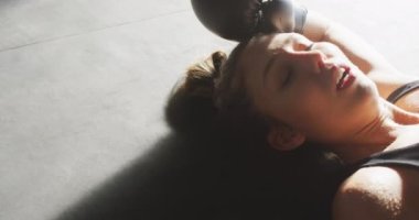 Spor salonunda kutu eğitiminden sonra dinlenen formda ve yorgun beyaz kadın videosu. aktif, formda, sportif ve sağlıklı yaşam tarzı, spor konsepti egzersizi.
