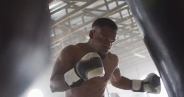 Afrika kökenli Amerikalı bir adamın spor salonunda boks yaptığı bir video. aktif, formda, sportif ve sağlıklı yaşam tarzı, spor konsepti egzersizi.
