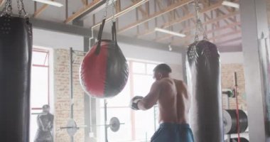 Afrika kökenli Amerikalı bir adamın spor salonunda boks yaptığını gösteren bir video. aktif, formda, sportif ve sağlıklı yaşam tarzı, spor konsepti egzersizi.