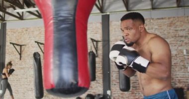 Afrika kökenli Amerikalı bir adamın spor salonunda boks yaptığı bir video. aktif, formda, sportif ve sağlıklı yaşam tarzı, spor konsepti egzersizi.