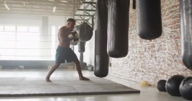 Afrika kökenli Amerikalı bir adamın spor salonunda boks yaptığı bir video. aktif, formda, sportif ve sağlıklı yaşam tarzı, spor konsepti egzersizi.