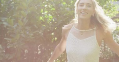 Güneşli bir günde bahçesinde çiçek tutan mutlu beyaz kadın. düğün günü ve kutlama konsepti.