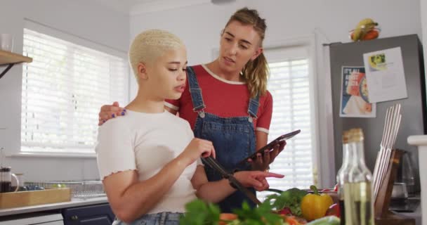 Feliz Pareja Femenina Diversa Cocinar Verduras Uso Tabletas Cocina Pasar — Vídeos de Stock
