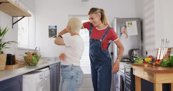 幸せな多様な女性のカップルを受け入れ キッチンで一緒に踊ります 家で質の高い時間を過ごす — ストック動画