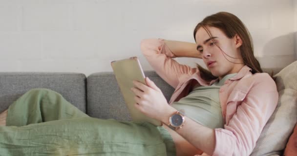 Mulher Transgênero Não Binária Caucasiana Deitada Sofá Usando Tablet Passar — Vídeo de Stock