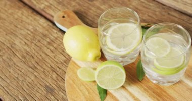 Tahta tahtada ve tahta yüzeyde limonlu limonlu bardakların videosu. içecekler, içecekler, ferahlatıcı ve ferahlatıcı konsept.