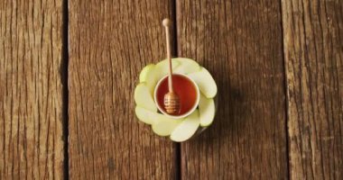 Ahşap yüzeyde duran bal ve elma dilimlerinin olduğu bir kavanoz. yemek, pişirme, pişirme, tat ve lezzet kavramı.