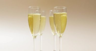 Bej arka planda şampanya bardaklı bir video. alkol, içecek, içecekler, parti ve kutlama konsepti.