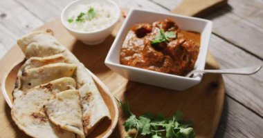 Video of tortillas, sauce and seasonings lying on board on wooden surface. cuisine, cooking, food preparing, taste and flavour concept.