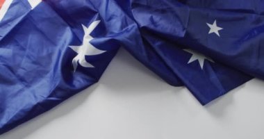 Beyaz arka planda yatan Avustralya bayrağının kırışık videosu. Milliyetler, devlet sembolleri, vatanseverlik ve bağımsızlık kavramı.