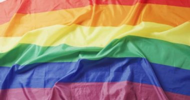 Beyaz arka planda duran buruşmuş gökkuşağı bayrağının videosu. Gay gururu, lgbt hakları ve azınlık konseptini destekleme.