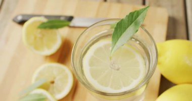 Tahta tahtada ve tahta yüzeyde limonlu cam ve limonlu bir video. içecekler, içecekler, ferahlatıcı ve ferahlatıcı konsept.