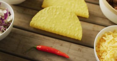 Tahta zeminde duran taco, passata, domates ve diğer malzemelerin videosu. Mutfak, yemek, yemek hazırlama, tat ve lezzet konsepti.