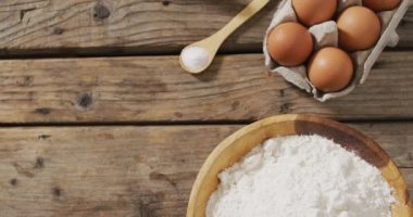Tahta yüzeyde un ve yumurtalı kase videosu. Pişirme, yemek hazırlama, tat ve lezzet kavramı.
