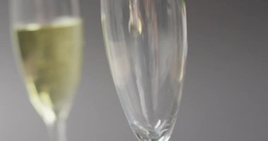 Video of champagne pouring into glass on grey background. alcohol, beverage, drinks, party and celebration concept.