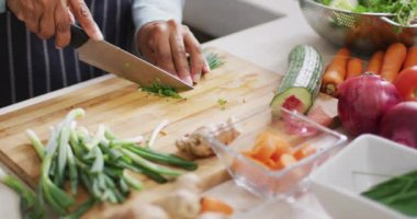 Asyalı son sınıf öğrencisinin evdeki mutfakta sebze doğradığı bölüm. emeklilik yaşam tarzı ve yaşam konsepti