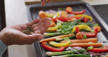 Sebze salatasının üzerine kekik serpiştiren Asyalı yaşlı kadının orta bölümü. emeklilik yaşam tarzı ve yaşam konsepti