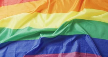 Beyaz arka planda duran buruşmuş gökkuşağı bayrağının videosu. Gay gururu, lgbt hakları ve azınlık konseptini destekleme.