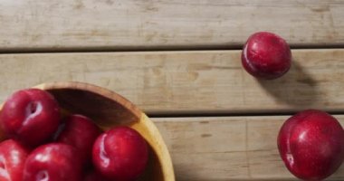 Tahta yüzeyde duran kasedeki taze eriklerin videosu. yiyecek, meyve, ferahlatıcı, tat ve lezzet kavramı.