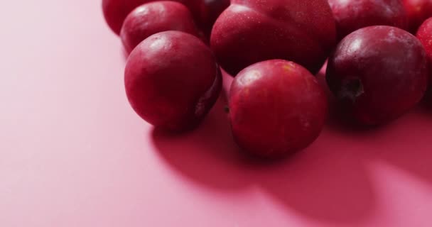 Video Van Verse Pruimen Liggend Roze Oppervlak Levensmiddelen Fruit Frisdranken — Stockvideo