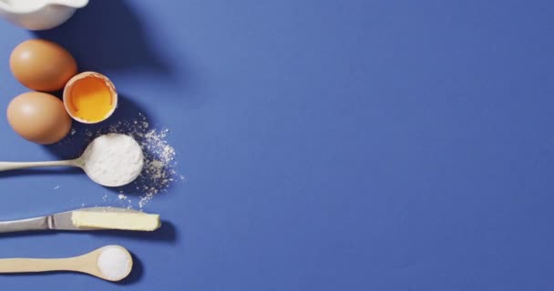 コピースペースのある青い表面に横たわるベーキング成分とスプーンのビデオ ベーキング 味と風味の概念 — ストック動画