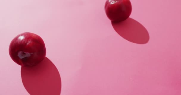Видео Свежих Слив Лежащих Розовой Поверхности Еда Фрукты Свежие Овощи — стоковое видео