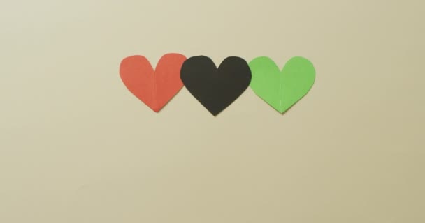 Video Van Rode Zwarte Groene Papieren Hartjes Beige Achtergrond Liefde — Stockvideo