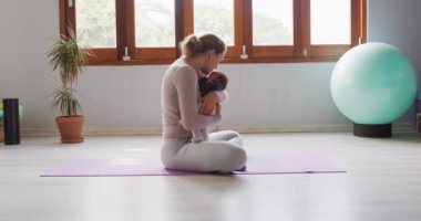 Kafkas anne ve yeni doğan bebeğin yoga minderinde videosu. annelik, ebeveyn sevgisi ve dijital olarak oluşturulan konsepte geri dönüş videosu.