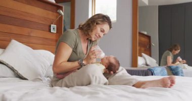 Kafkasyalı mutlu bir annenin yeni doğan bebeği şişeyle beslediği video. annelik, ebeveyn sevgisi ve yeni doğan bebek konseptiyle ilgilenmek dijital olarak üretilmiş video.