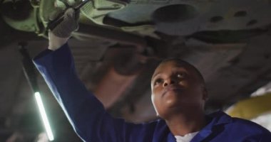 Afrika asıllı Amerikalı kadın araba tamircisinin araba kontrol videosu. Araba tamirhanesinde çalışmak ve küçük kadınsı iş konsepti yürütmek..