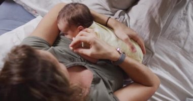 Yeni doğan bebeği besleyen beyaz bir annenin videosu. annelik, ebeveyn sevgisi ve yeni doğan bebek konseptiyle ilgilenmek dijital olarak üretilmiş video.