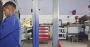 Afrika asıllı Amerikalı kadın araba tamircisinin lastik değiştirdiği bir video. Araba tamirhanesinde çalışmak ve küçük kadınsı iş konsepti yürütmek..