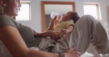 Kafkasyalı mutlu bir annenin yeni doğan bebeği şişeyle beslediği video. annelik, ebeveyn sevgisi ve yeni doğan bebek konseptiyle ilgilenmek dijital olarak üretilmiş video.